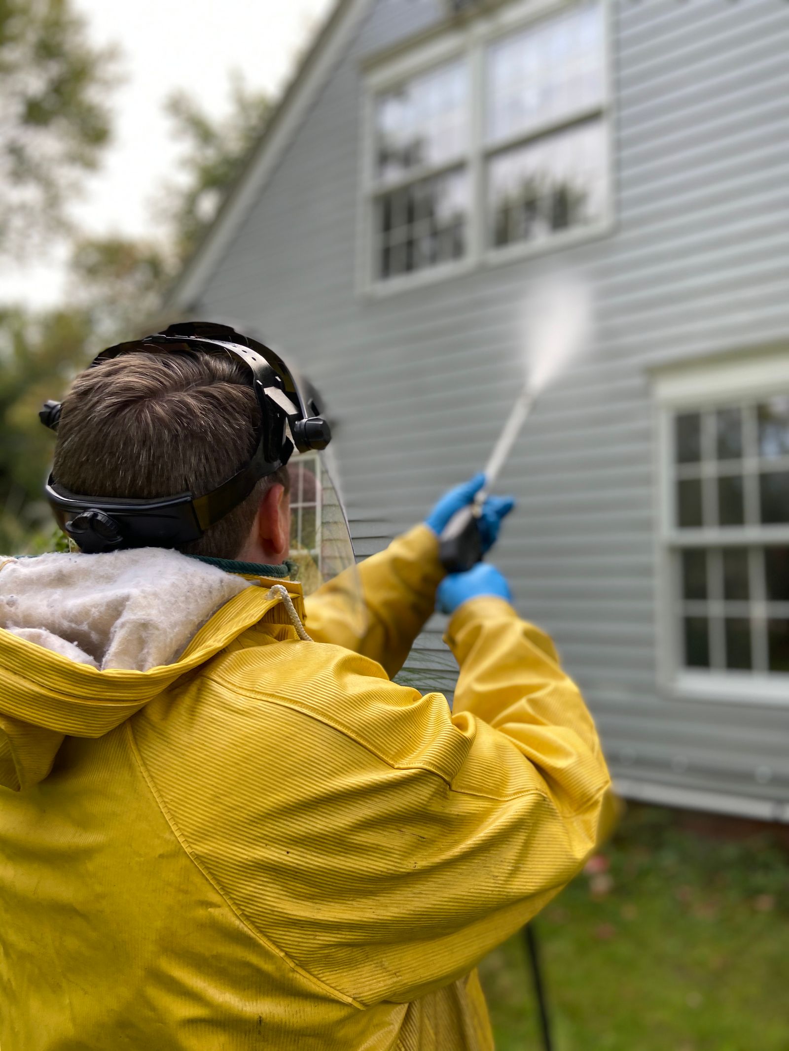 A pressure washer cleaning an exterior wall